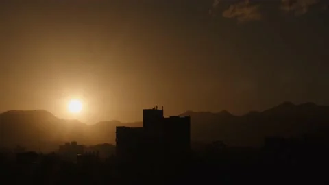 Day to night time lapse sunset silhouet mountains and building Stockbeeldmateriaal 151691475