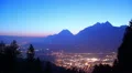 Day to night timelapse of big city, mountain shadow background HD Footage