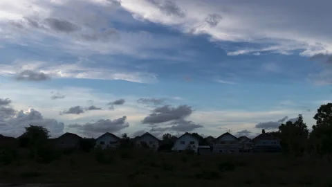 Day to night timelapse of massive cloud passing over six houses. Stock Footage 156382305