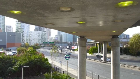 Day time London DLR bridge car traffic skyscrapers Canary Wharf Stock Footage 100972389