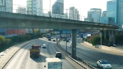 Day time London DLR bridge car traffic skyscrapers Canary Wharf Stock Footage 100972672