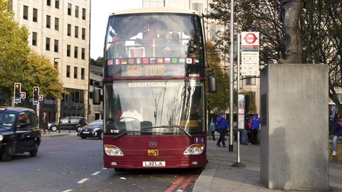 Day time London red double decker excursion bus stop Stock Footage 100973794