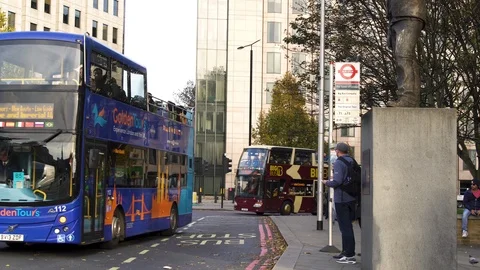 Day time London red double decker excursion bus stop Stock Footage 101016100