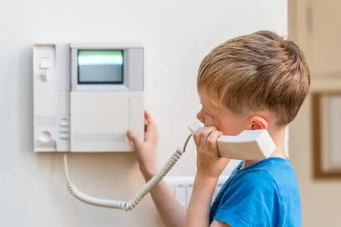 Day view blond boy talking via intercom in UK Photos