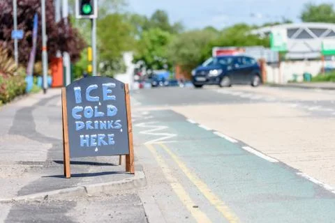 Day view Ice Cold Drinks Here wooden sign on British sidewalk Photos
