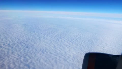 Daybreak aboard a passenger plane flying above the clouds. Stock Footage 166316800