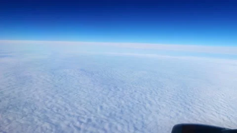 Daybreak aboard a passenger plane flying above the clouds. Video stock 167714055
