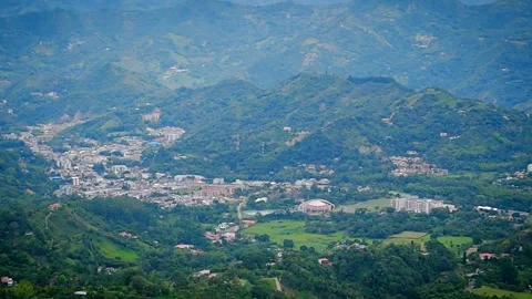 Daylight panoramic view of mountain range with valley town nestled below Video stock 316791126