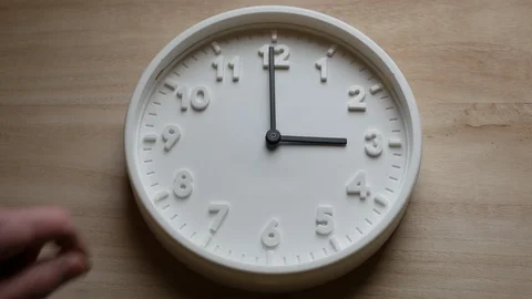 Daylight saving time ends, clock is turned backward by one hour by a man's hand Stock Footage 127012793