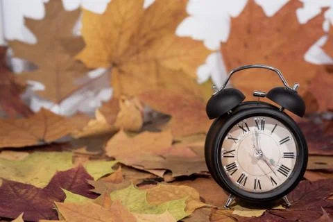 Daylight Saving Time. Wall Clock going to winter time. Autumn abstraction. Stock Photos