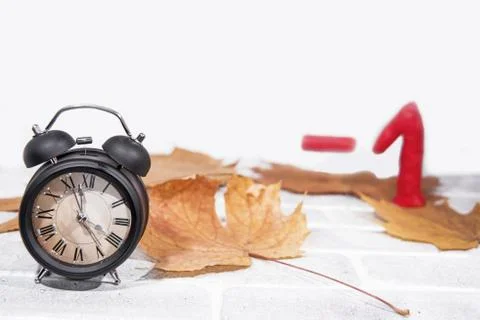 Daylight Saving Time. Wall Clock going to winter time. Autumn abstraction. Stock Photos
