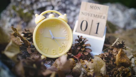 Daylight saving time yellow alarm clock first november fall back time change Stock Footage 162028583