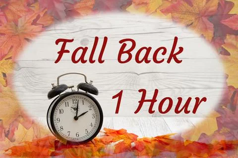 Daylight Savings Fall Back message with alarm clock with fall leaves Stock Photos