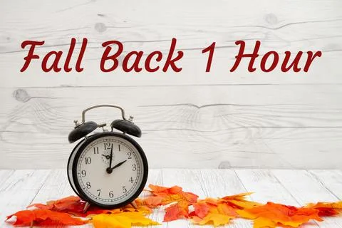Daylight Savings Fall Back message with alarm clock with fall leaves Stock Photos