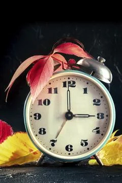 Daylight Savings Time concept, fall back in autumn. A retro alarm clock with Stock Photos
