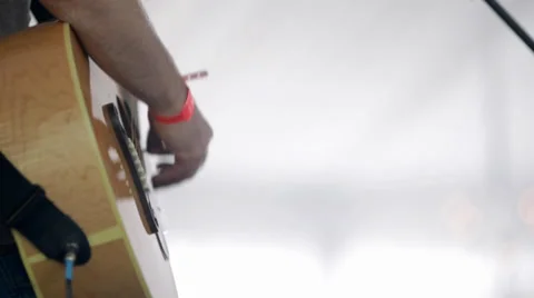 Daylight shot of man playing electro acoustic guitar Stock Footage 36807753