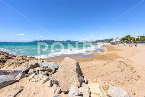 Daylight sunny view from rocks to blue sea and mountains Stock Photos