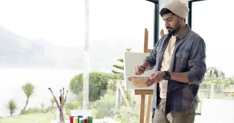 Daylight urging Indian painter at window stirring in bowl gazing and smiling at 库存影片 343837819