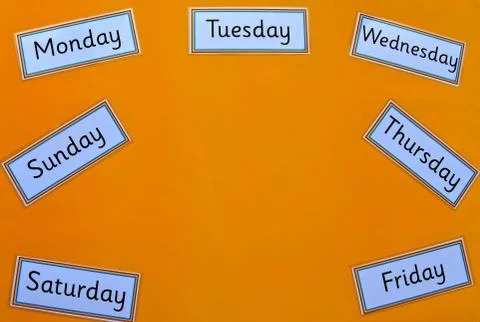 Days of the week flatlay on yellow background. Stock Photos