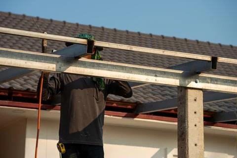 Daytime action shot construction worker installing steel framework in urban.. Stock Photos