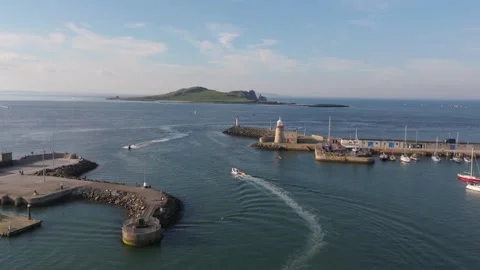 Daytime Drone Flyover of Powerboat Leaving Irish Harbour Toward Offshore Island Stock Footage 339409076