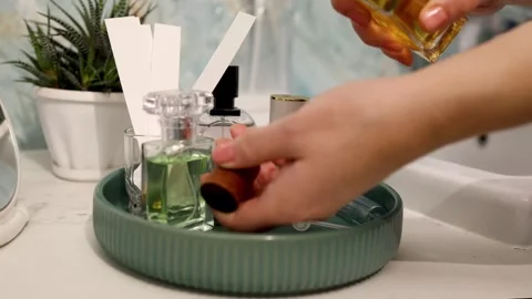 Daytime fragrance testing: still life of perfume bottles on a green ribbed Vidéo 343671966