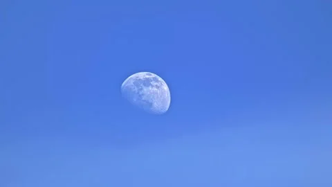 Daytime moon on blue sky with light haze and atmospheric distortion Stock Footage 234428876