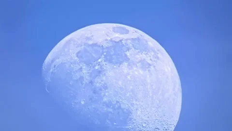 Daytime moon close-up with craters on blue sky and atmospheric distortion Video stock 234429359
