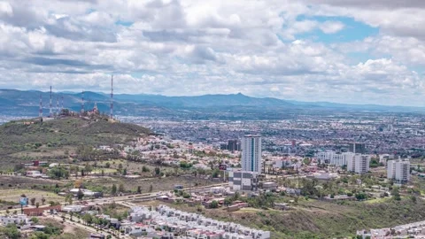 A daytime panoramic view with a partly cloudy sky. An urban area surrounded by Stock Footage 341494004