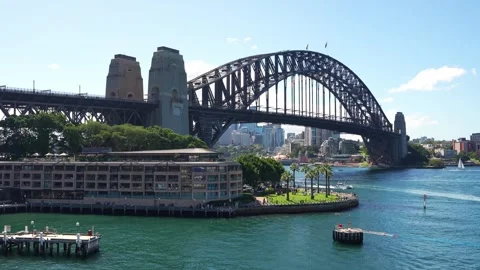 A daytime time-lapse of the iconic Sydney Harbour Bridge spanning the blue Stock Footage 344266378