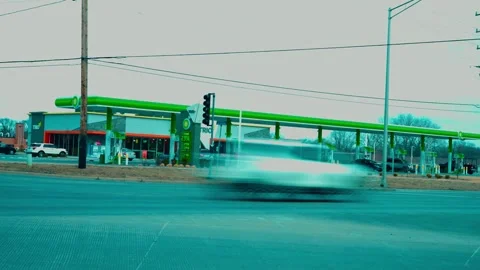 Daytime timelapse of a bustling BP gas station, featuring fast commuter street Видео 331315449
