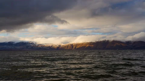 Daytime Timelapse of moving clouds over lake Sevan on background hills. Stock Footage 98488081