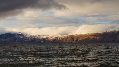 Daytime Timelapse of moving clouds over lake Sevan on background hills Stock Footage 98488806