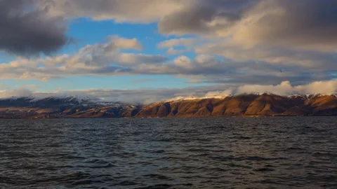 Daytime Timelapse of moving white, gray clouds over lake Sevan on background Stock Footage 98488795