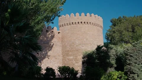 Daytime View of Medieval Stone Castle Tower Surrounded by Greenery Stock Footage 338244315
