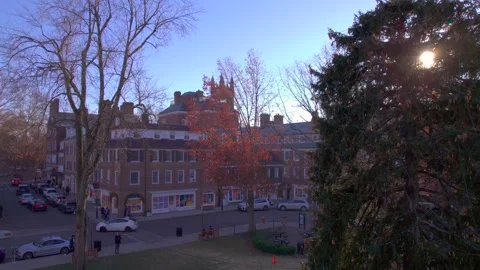 Daytime view of a quaint town square with cars and pedestrians Stock Footage 345259198