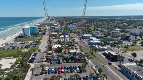 Daytona Beach Aerial pull back from sling ride to coastline view Stock Footage 280209261