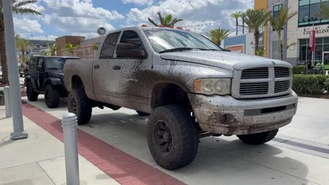 Daytona Beach, FL. Big 4 wheel drive muddy dirty pick up truck Stock Footage 236873884