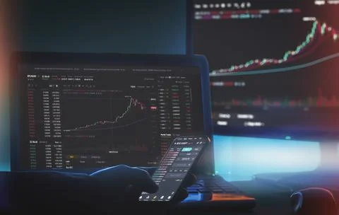 Daytrader working from home using Binance app on Computer screen and phone wi Stock Photos