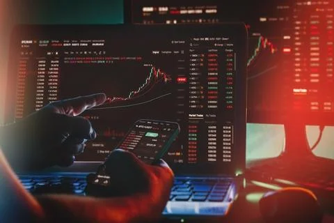 Daytrader working from home using Binance app on Computer screen and phone wi Stock Photos