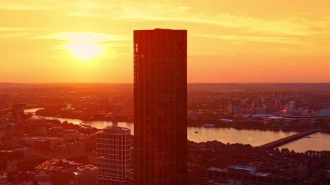 Dazzling orange light of setting sun covers the city panorama. Drone flight over Stock Footage 339750057