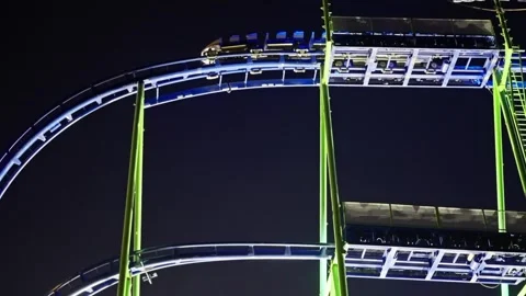 A dazzling view of a roller coaster structure illuminated at night, showcasing Stock Footage 321611863