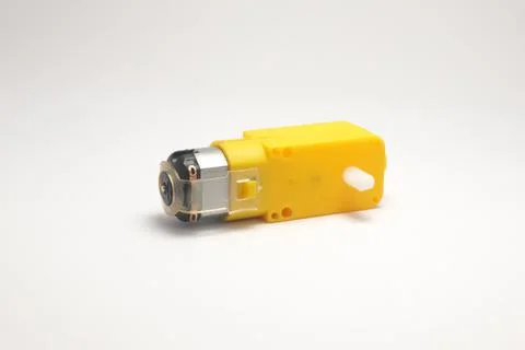 A DC motor with its power socket equipped with a yellow gearbox side view on  Stock Photos
