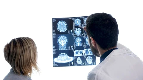 Dcotor with a patient checking a MRI scan in front of big white dispaly Stock Footage 92020535