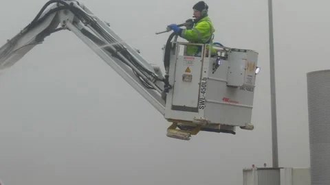 De-ice / de-icing airplane wings prior to take off in cold weather in Manchester Stock Footage 244813272