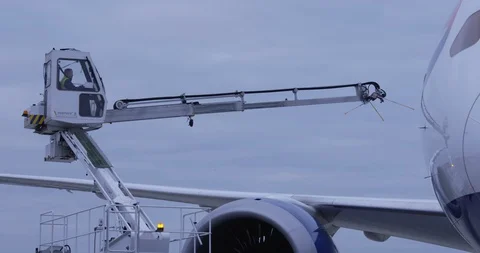 De-icing machine moving across plane wing, preparing to spray de-icer Stock Footage 114037919