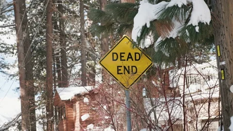 Dead End Sign with Snow Falling in Background SLOMO 4k Stock Footage 235637894