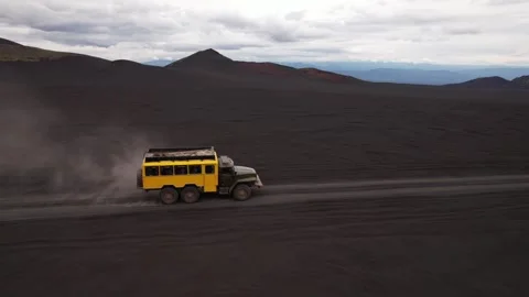 Dead forest Kamchatka. Black sand of Kamchatka. Yellow truck.4K Video stock 253546682
