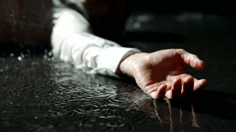 Dead man in puddle in rain in night, closeup view of hand, crime scene, flashes Vidéo 205005635
