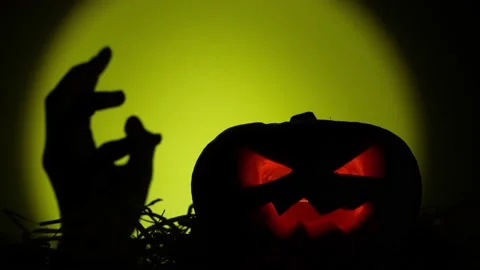 A dead man's hand rises from under the ground near halloween pumpkin Stock Footage 219575844